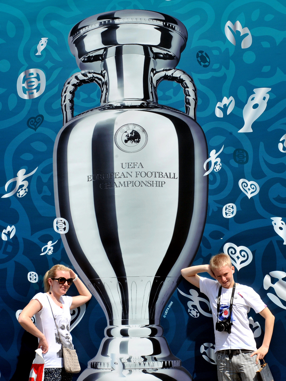 Larger Than Life: Tourists pose in front of a UEFA Euro 2012 Cup placard on Kiev's Independence Square in Ukraine. Europe is entering a packed sports schedule — but soccer still reigns supreme, says Frank Deford.