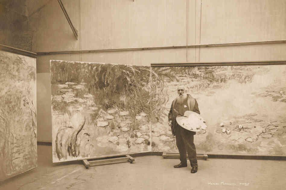 Monet works on one of his many water lily paintings in his studio at Giverny in 1920.