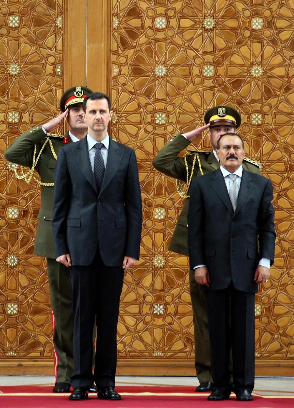 In this photo from 2009, Syrian President Bashar Assad (left) stands with then-Yemeni President Ali Abdullah Saleh during a welcoming ceremony for Saleh at the presidential palace in Damascus. As the violence continues in Syria, the U.S. and other countries are hoping to convince Assad to step down from power, as Saleh did.
