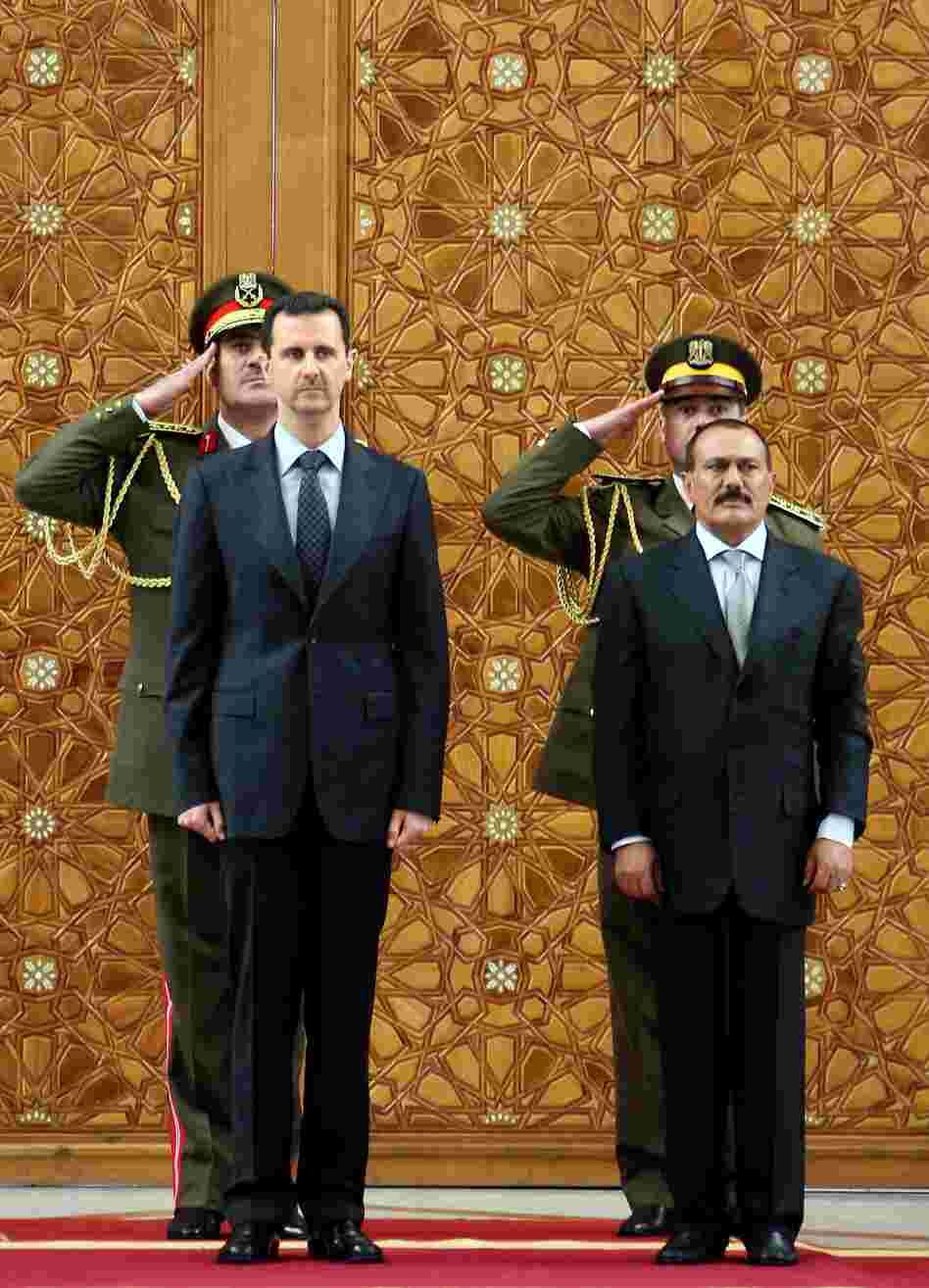 In this photo from 2009, Syrian President Bashar Assad (left) stands with then-Yemeni President Ali Abdullah Saleh during a welcoming ceremony for Saleh at the presidential palace in Damascus. As the violence continues in Syria, the U.S. and other countries are hoping to convince Assad to step down from power, as Saleh did.