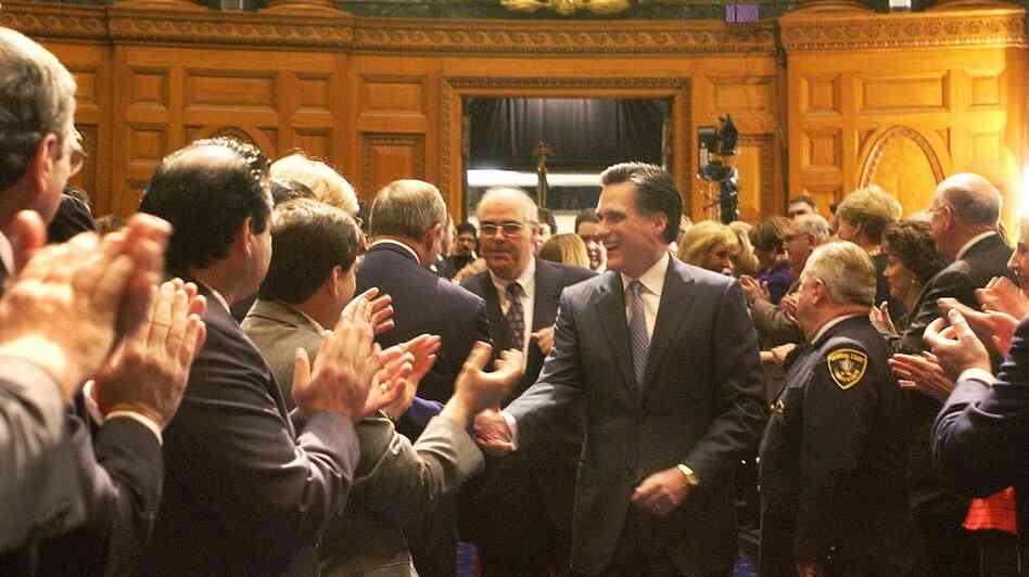 Mitt Romney shakes hands as he walks into the House Chambers during inaugural ceremonies at the State House in Boston in 2003. the Obama campaign sought to focus attention on Romney's tenure as Massachusetts governor.