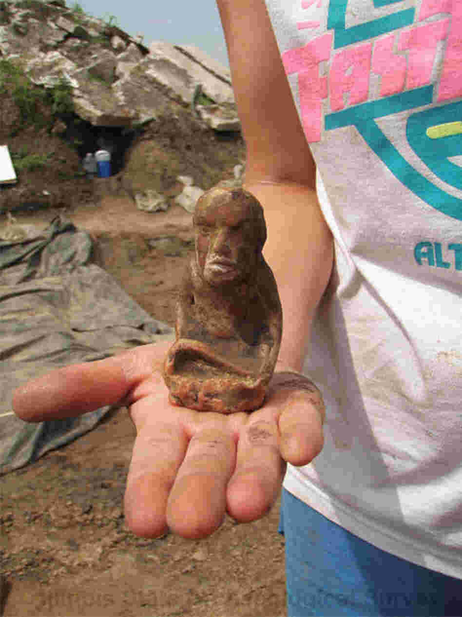 This figurine found at the East St. Louis dig site is made of a type of pipestone called Missouri flint clay. It portrays a kneeling woman holding a marine shell cup — possibly a fertility goddess.