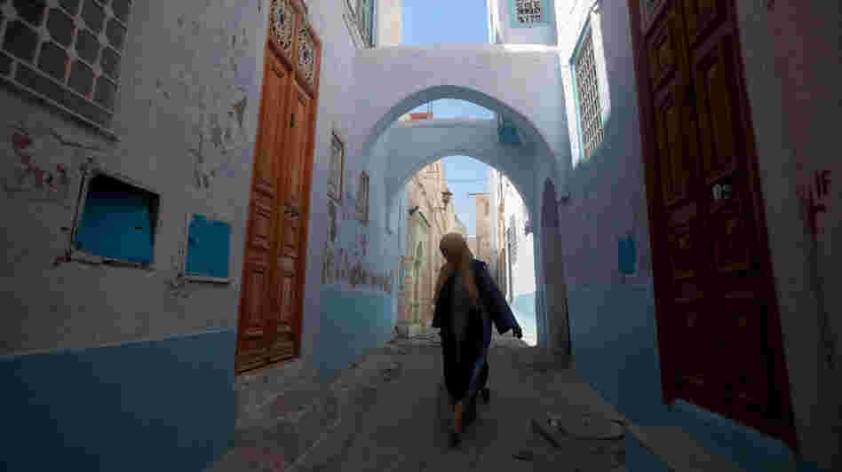 A woman walks the narrow streets of the old city in Kairouan.