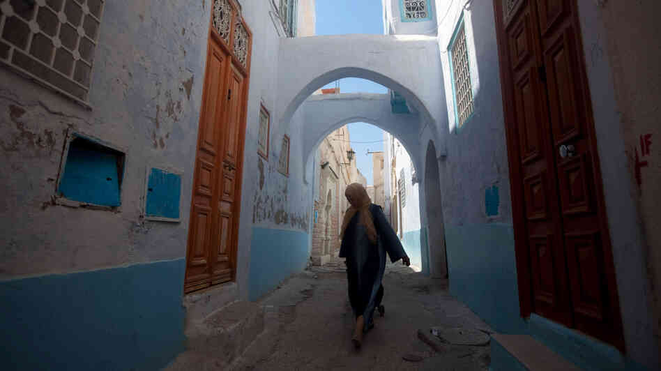 A woman walks the narrow streets of the old city in Kairouan.