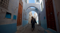 A woman walks the narrow streets of the old city in Kairouan.