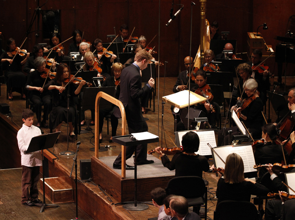 Very Young Composer Milo Poniewozik joins assistant conductor Joshua Weilerstein at the head of the New York Philharmonic. As part of the orchestra's School Day Concerts, Milo's piece was performed in front of more than 2,000 kids.