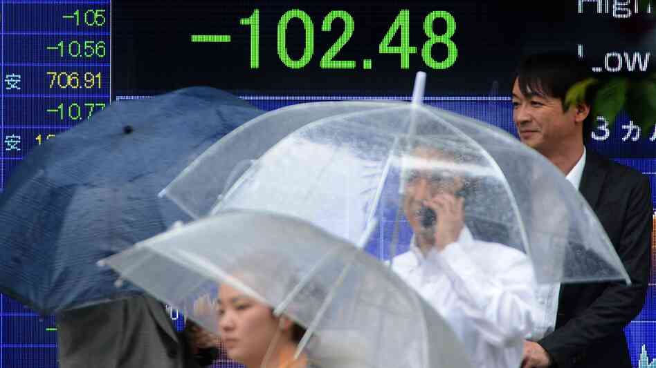 Slow economic growth in the U.S. is having an impact on many countries around the world. Here, people walk past a board flashing the Nikkei index on the Tokyo Stock Exchange in Japan last month. Slow economic growth in the U.S. is having an impact on many countries around the world. Here, people walk past a board flashing the Nikkei index on the Tokyo Stock Exchange in Japan last month.