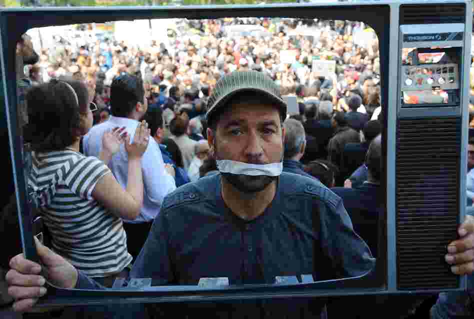A Tunisian journalist holds a TV frame as part of a protest in Tunis against actions taken against the media. Since last year's revolution, Tunisians have been able to speak more freely about politics and social issues. But with the rise of Islamist groups, religion has become a more sensitive topic.