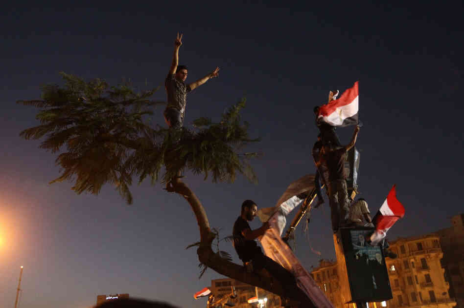 Protesters hold Egyptian flags during the demonstration in Tahrir Square.