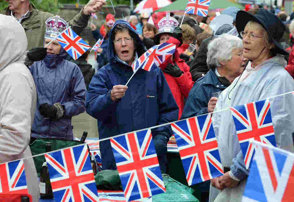 Crowds swelled into the thousands, with revelers in hats, flags, leggings and rain ponchos adorned with the Union flag mixing with burger and cotton-candy vendors along the 7-mile route along the Thames.