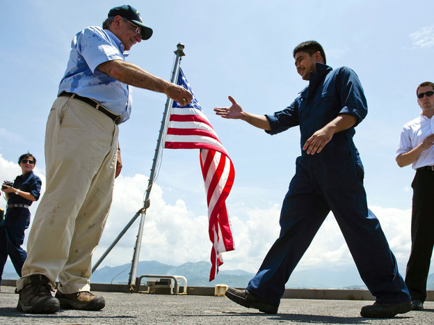 U.S. Defense Secretary Leon Panetta hands out coins to members of the crew as he visits USNS Richard E. Byrd in Cam Ranh Bay, Vietnam, on Sunday. Panetta toured the former U.S. air and naval base in the bay, becoming the most senior American official to go there since the war ended.