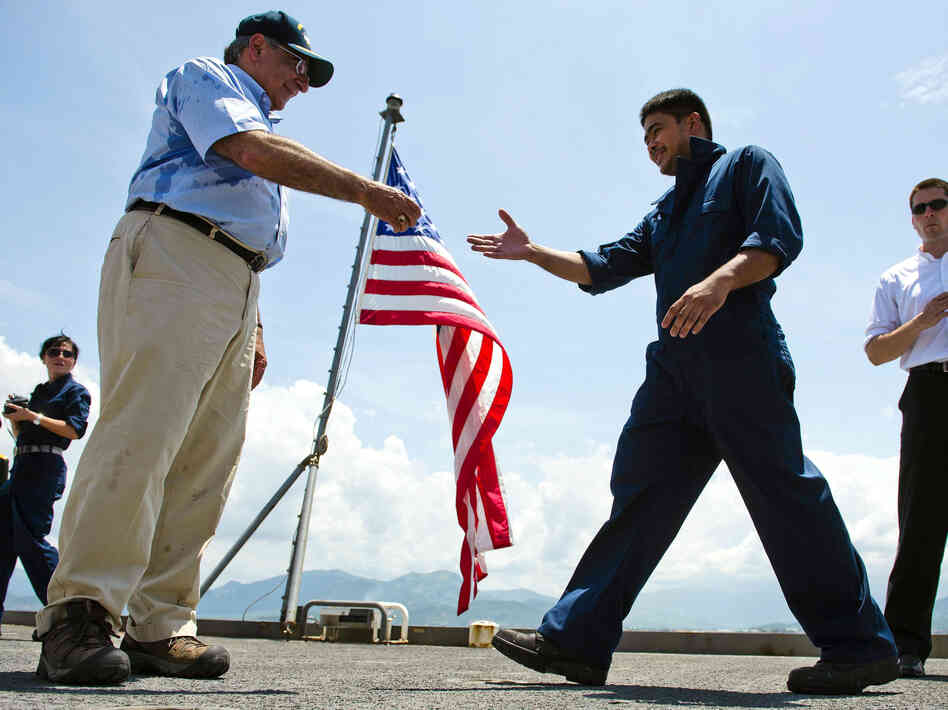U.S. Defense Secretary Leon Panetta hands out coins to members of the crew as he visits USNS Richard E. Byrd in Cam Ranh Bay, Vietnam, on Sunday. Panetta toured the former U.S. air and naval base in the bay, becoming the most senior American official to go there since the war ended.