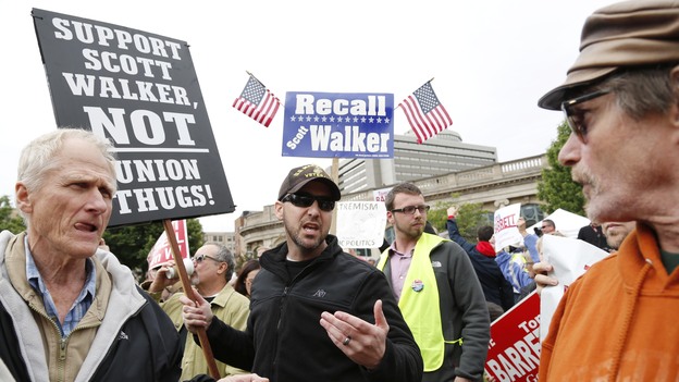 A supporter of Wisconsin Gov. Scott Walker (right) talks with a supporter of Walker's Democratic opponent, Tom Barrett, at a recall election rally Friday on Friday.