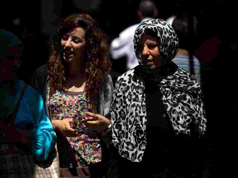 Tunisian women walk through the narrow streets of Tunis' medina, or marketplace. Compared to women in other Arab countries, Tunisian women have had access to education and job opportunities for decades.