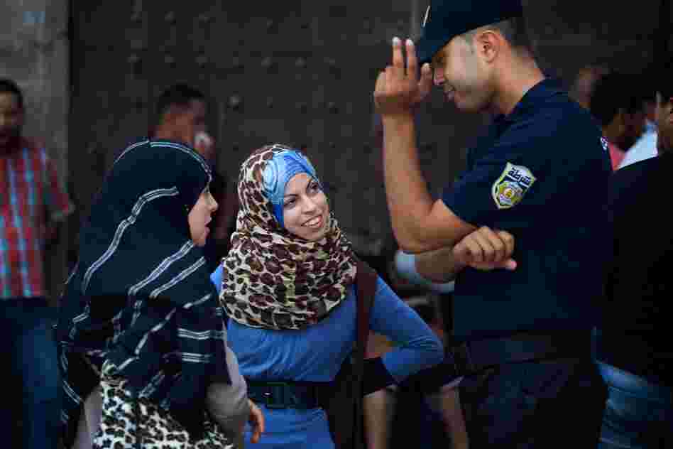 Women talk with a police officer in Tunis.