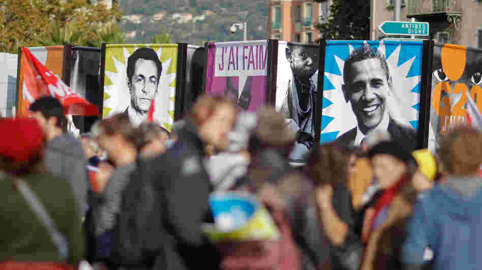 Protesters in Nice, France, hold banners depicting then-French President Nicolas Sarkozy and President Obama before a November 2011 G-20 summit where global financial issues were discussed. Sarkozy has since lost re-election; some political scientists say economic problems in Europe also could play an unprecedented role in the upcoming U.S. election.