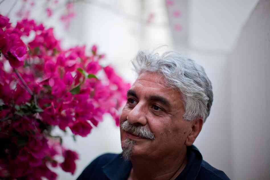 Jacob LaLoush poses beside bougainvillea flowers outside his kosher restaurant in Sidi Bou Said, outside Tunis. He says his is the only kosher restaurant left in all of Tunis.