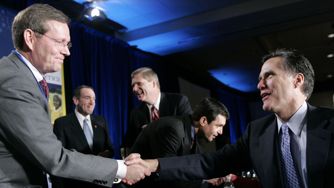Mitt Romney (right), at the time the governor of Massachusetts, greets then-Health and Human Services Secretary Mike Leavitt during a National Governors Association forum in February 2006. Romney reportedly has tapped Leavitt to head his presidential transition team.
