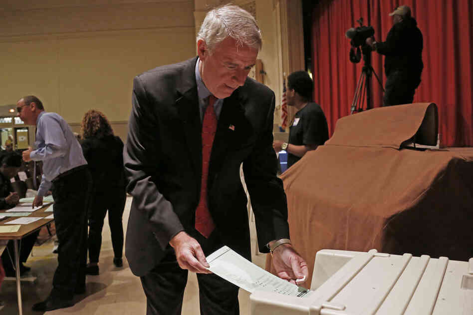 Barrett puts his ballot into a machine after voting in Milwaukee.