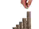 man putting coins on pile man putting coins on pile