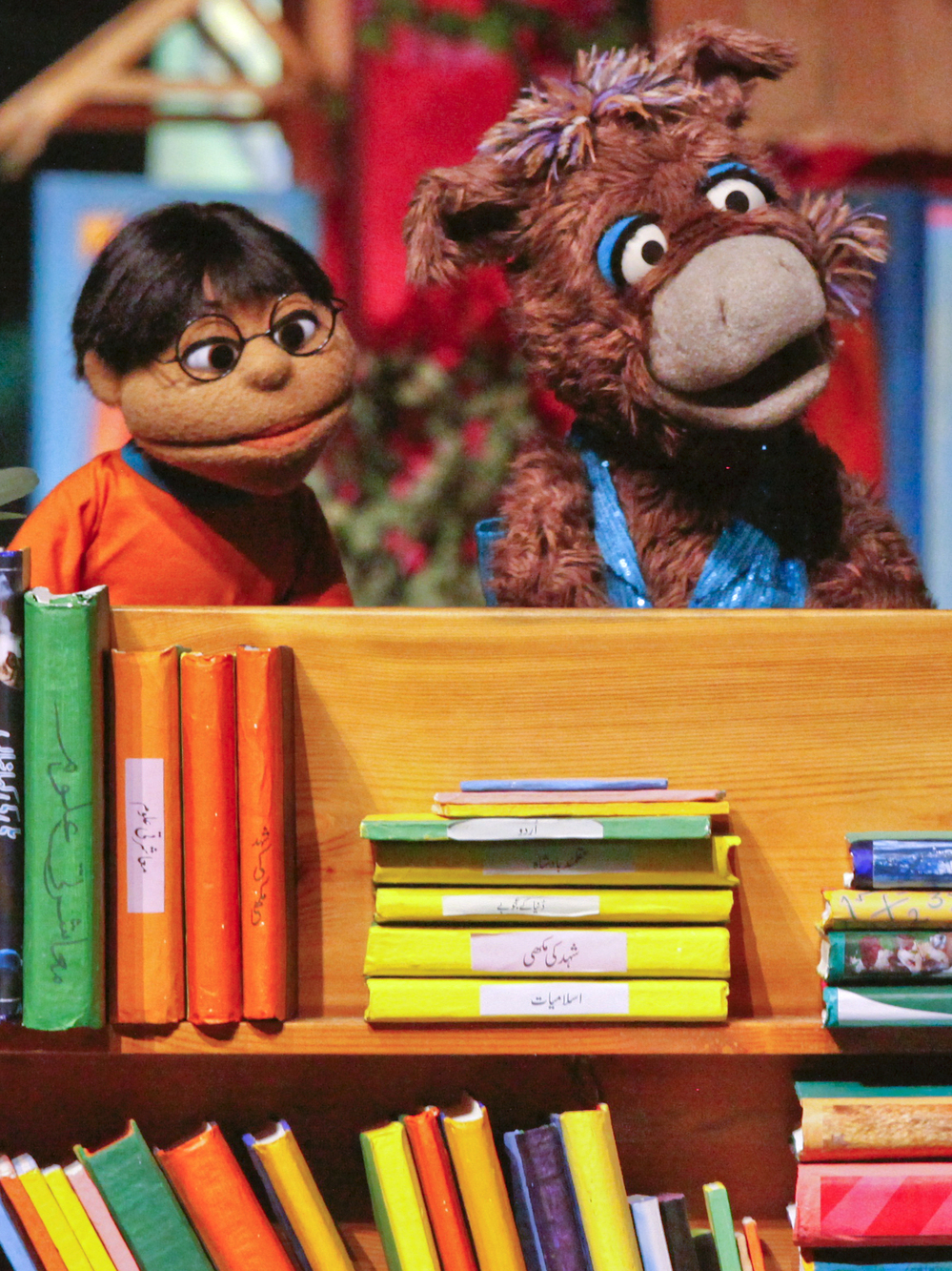 Baily the donkey (right) and Munna, characters from the Pakistani version of Sesame Street, perform at the launch ceremony for the show, Sim Sim Hamara, at Rafi Peer Theater Workshop in Lahore, Nov. 26, 2011.