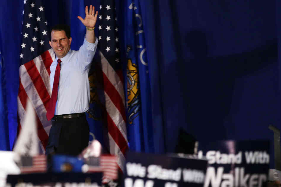 Wisconsin Gov. Scott Walker waves at his victory party Tuesday in Waukesha, Wis. The Republican survived a recall election in the state, defeating his Democratic rival, Tom Barrett.