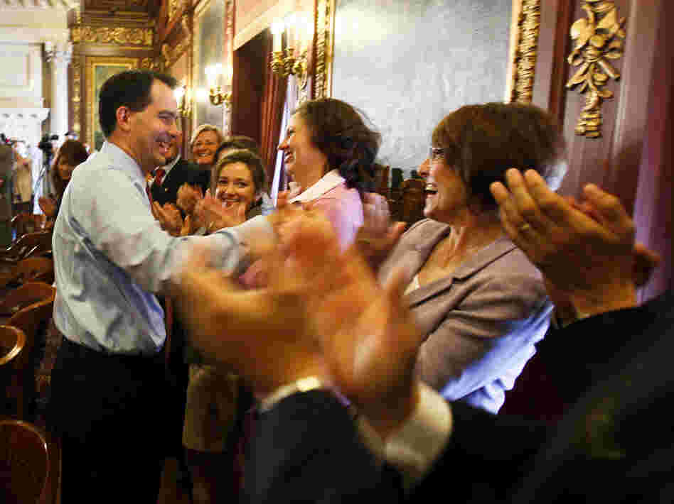Wisconsin Gov. Scott Walker is greeted by his Cabinet and staff at the state Capitol in Madison on Wednesday, a day after he defeated Milwaukee's Democratic mayor, Tom Barrett, in a recall election.