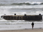 A man looks at the massive dock from Japan that washed ashore on Oregon's Agate Beach this week. A man looks at the massive dock from Japan that washed ashore on Oregon's Agate Beach this week.