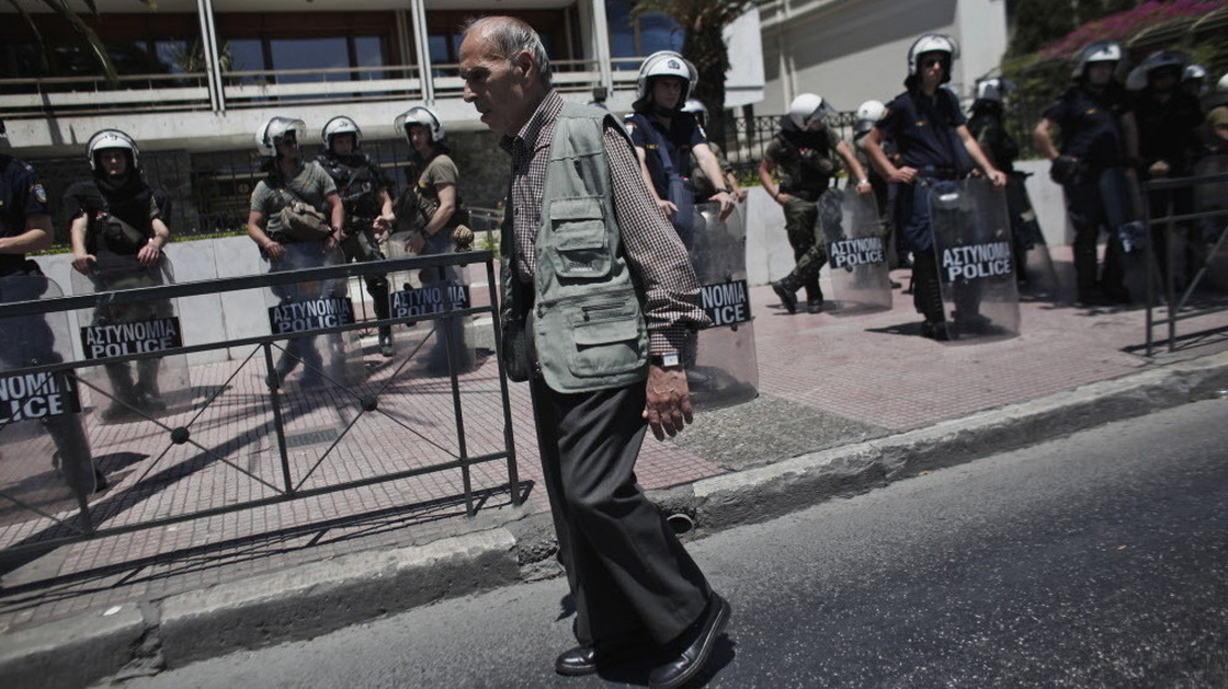 An elderly man walked by riot policemen guarding the Interior Ministry in Athens on Wednesday.
