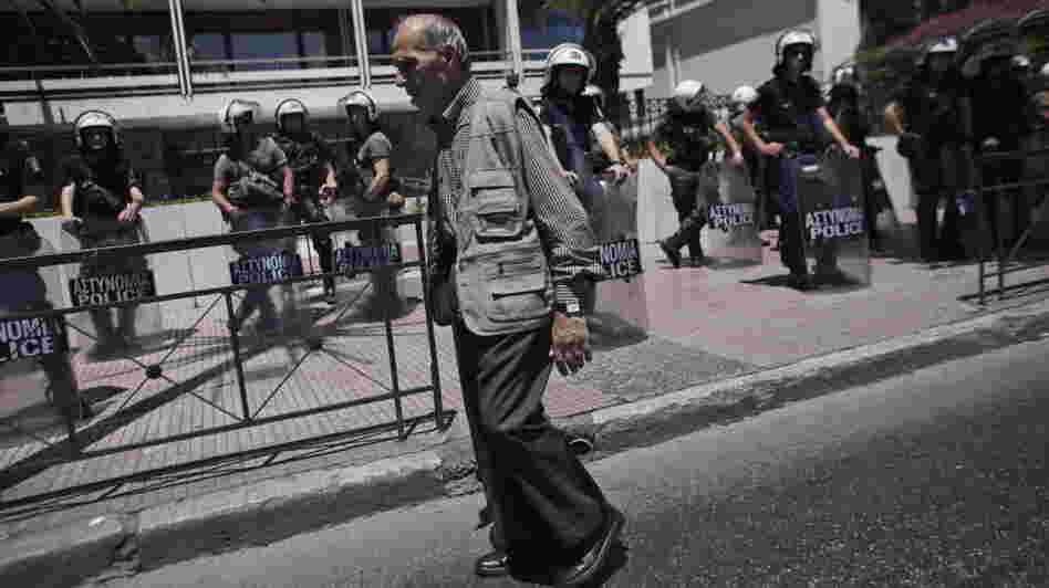 An elderly man walked by riot policemen guarding the Interior Ministry in Athens on Wednesday.