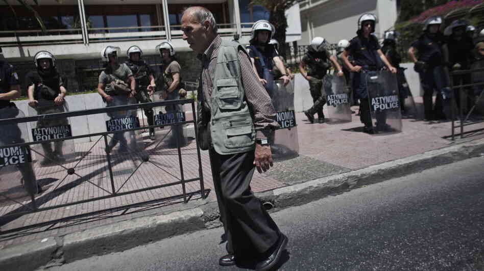 An elderly man walked by riot policemen guarding the Interior Ministry in Athens on Wednesday.