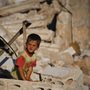 A Syrian boy sits in the rubble of house which was destroyed during a military operation by the Syrian pro-Assad army in April in the town of Taftanaz, Syria.