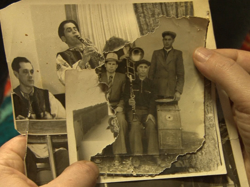 A Roma musician examines a photo of his Jewish ancestors in the film Der Zerbrochene Klang.