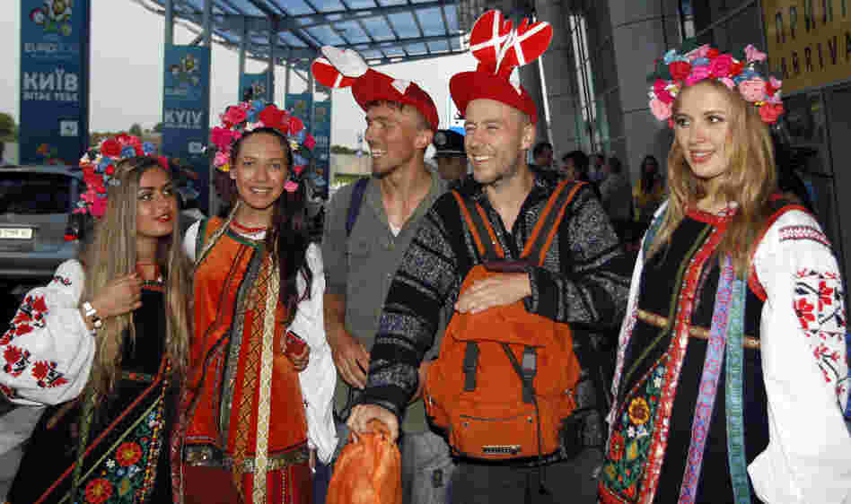 Soccer fans pose with Ukrainian girls dressed in traditional costumes at the airport in Kiev, the capital, Wednesday. The former Soviet state, together with Poland, is co-hosting the Euro 2012 soccer championship.