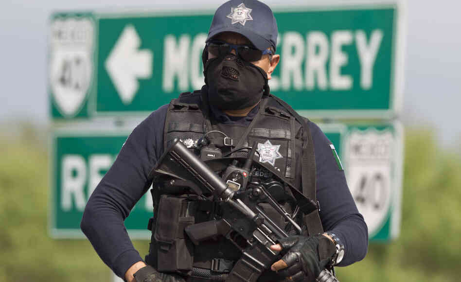 A Mexican federal policeman guards the area where dozens of bodies, some of them mutilated, were found on a highway outside the northern Mexican city of Monterrey on  May 13. The murders were one of the latest episodes in Mexico's brutal and unrelenting drug war.
