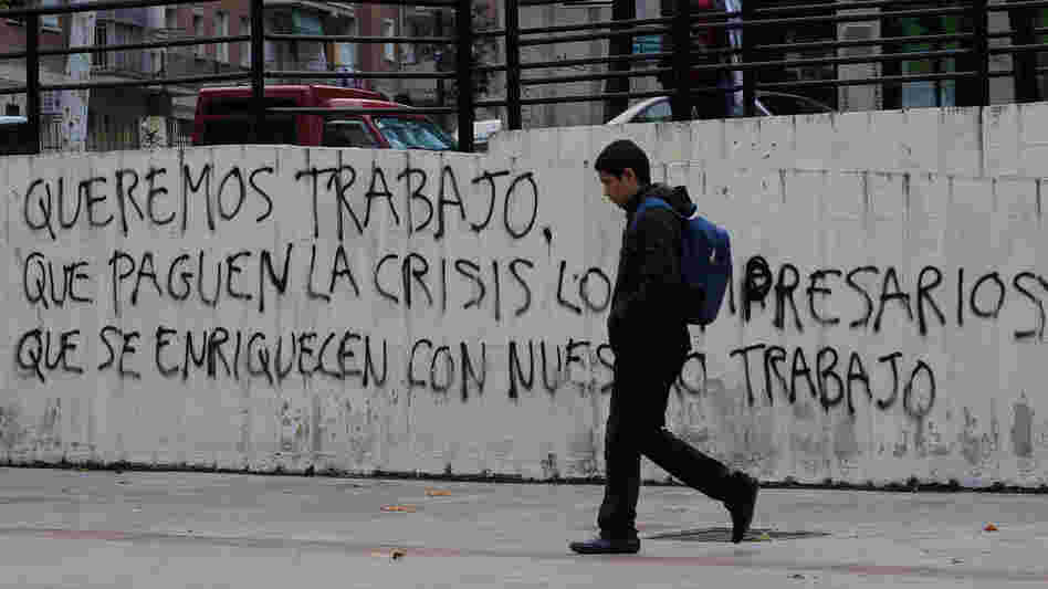 Graffiti on a wall in Madrid reads, "We want to work, let the businessmen who have gotten rich from our labor pay for the crisis." Nearly 50 percent of young adults in Spain are unemployed.