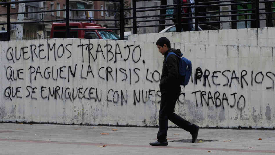 Graffiti on a wall in Madrid reads, "We want to work, let the businessmen who have gotten rich from our labor pay for the crisis." Nearly 50 percent of young adults in Spain are unemployed.