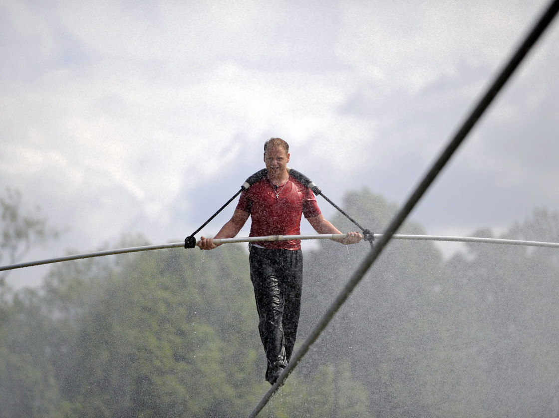 Nik Wallenda walks a tightrope in the rain during a training session for his upcoming stunt in Niagara Falls, N.Y.