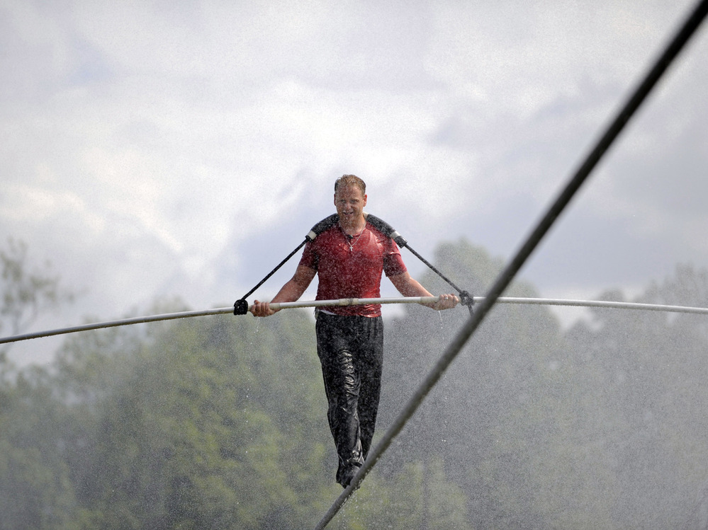 Nik Wallenda walks a tightrope in the rain during a training session for his upcoming stunt in Niagara Falls, N.Y.