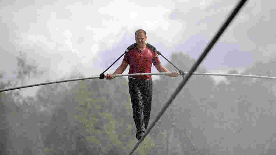 Nik Wallenda walks a tightrope in the rain during a training session for his upcoming stunt in Niagara Falls, N.Y.