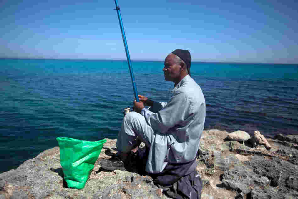 A man fishes in the Mediterranean outside a Tawargha refugee camp on the outskirts Tripoli. The people of Tawargha fled their ancestral homeland after the revolution when people from the city of Misrata accused them of collaborating with Gadhafi.