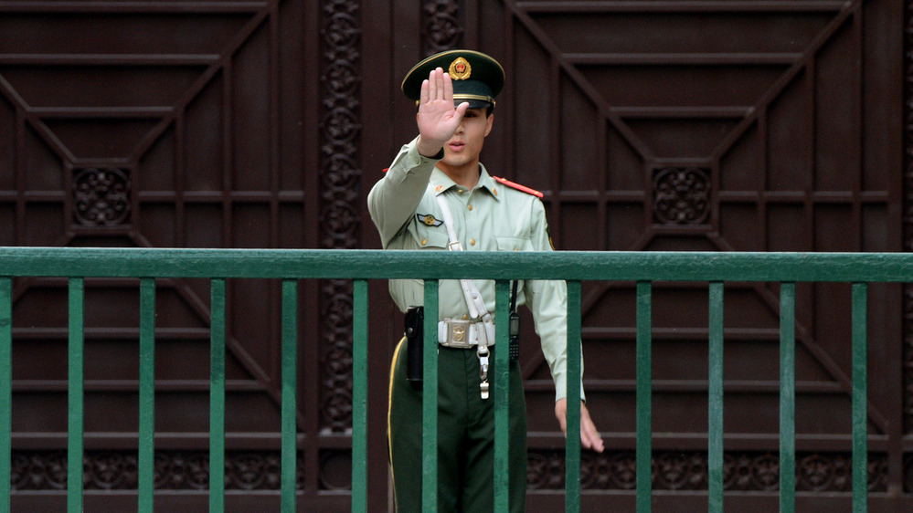 A Chinese paramilitary guard gestures outside the North Korean Embassy in Beijing on May 17. Tensions between the two countries are rising after unidentified North Koreans hijacked three Chinese fishing boats and demanded ransom, before releasing the vessels and their crew.