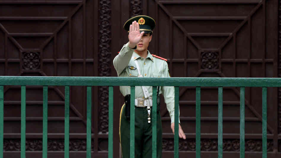 A Chinese paramilitary guard gestures outside the North Korean Embassy in Beijing on May 17. Tensions between the two countries are rising after unidentified North Koreans hijacked three Chinese fishing boats and demanded ransom, before releasing the vessels and their crew.
