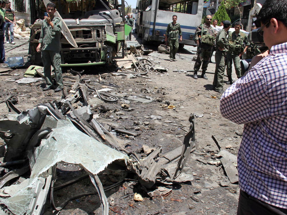 Syrian security forces inspect the scene of an explosion Friday in Damascus.