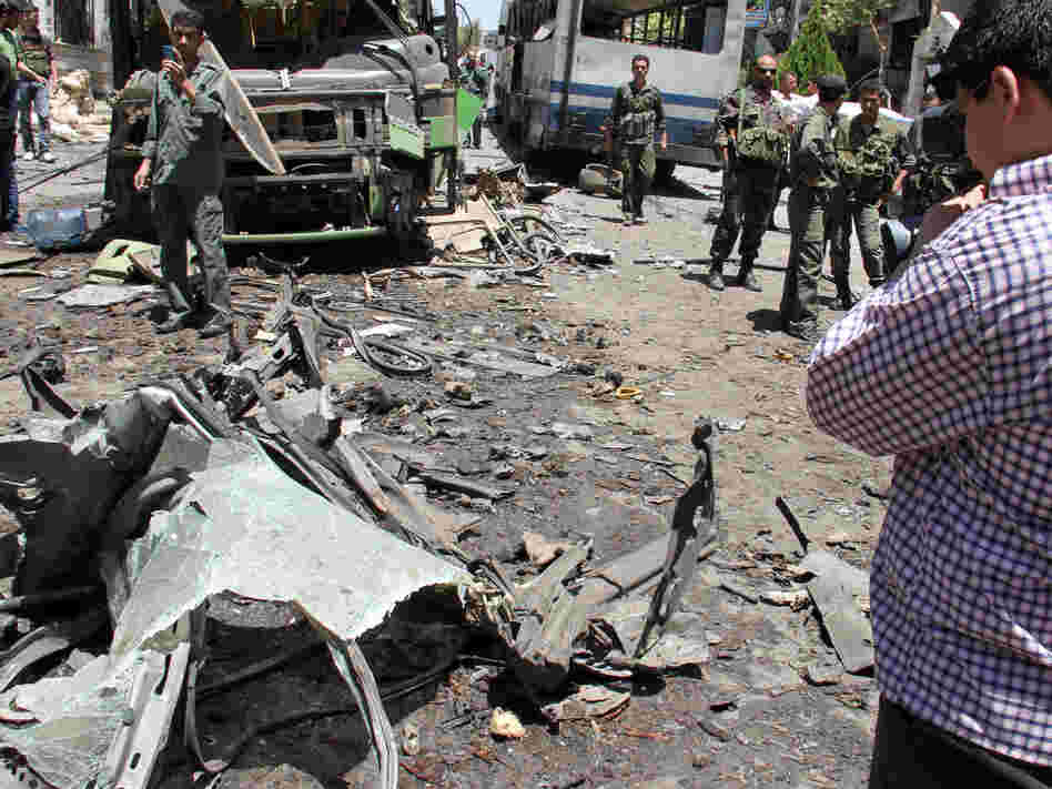Syrian security forces inspect the scene of an explosion Friday in Damascus.