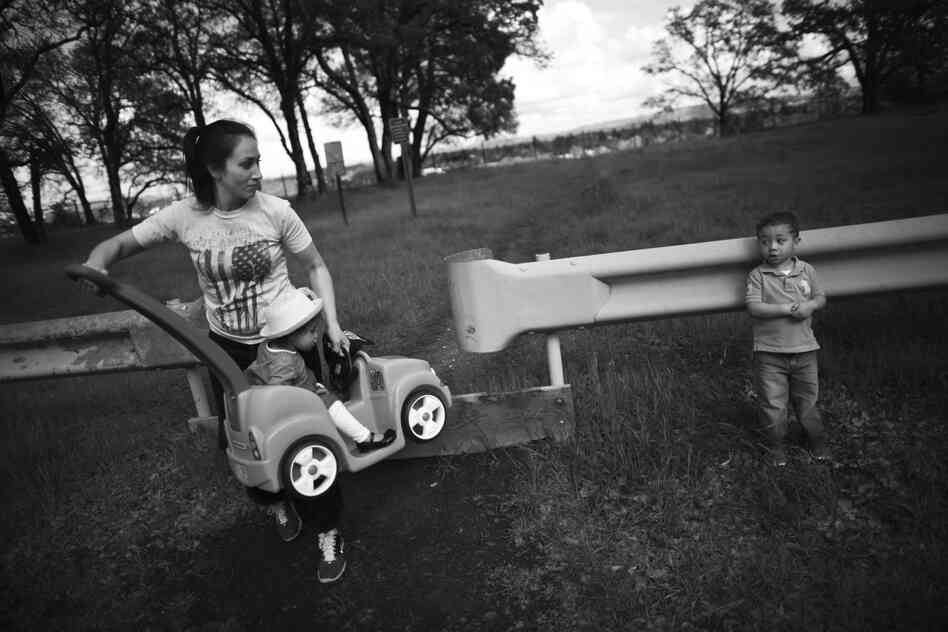 Marine veteran Crystal Turner, a student at Sierra College, holds her daughter, Marley Rose, while she tries to coax her son, Michael, into finishing a walk in the park near their home in Sacramento.