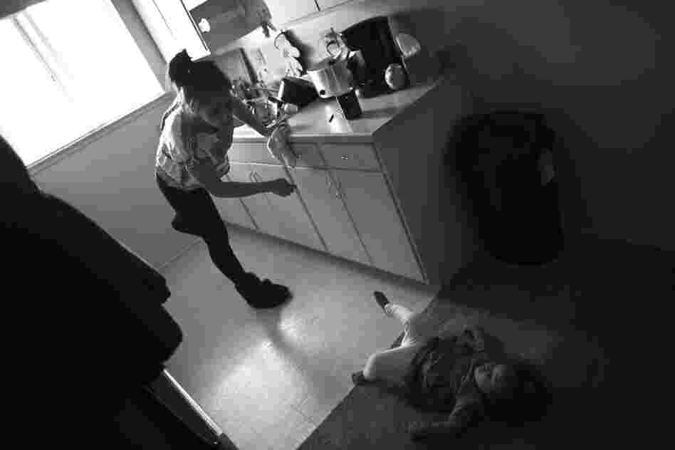 Marley Rose looks up at her mother while playing in the kitchen of their family home near Sacramento. Crystal Turner is mostly raising her two children on her own because her husband, who is also a Marine, lives two hours away near his base.