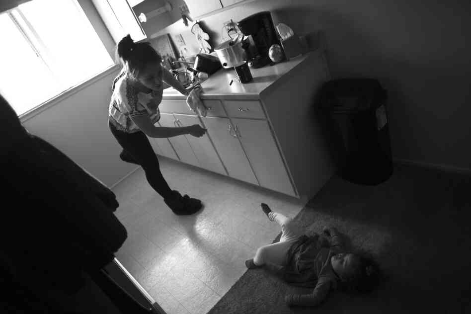 Marley Rose looks up at her mother while playing in the kitchen of their family home near Sacramento. Crystal Turner is mostly raising her two children on her own because her husband, who is also a Marine, lives two hours away near his base.