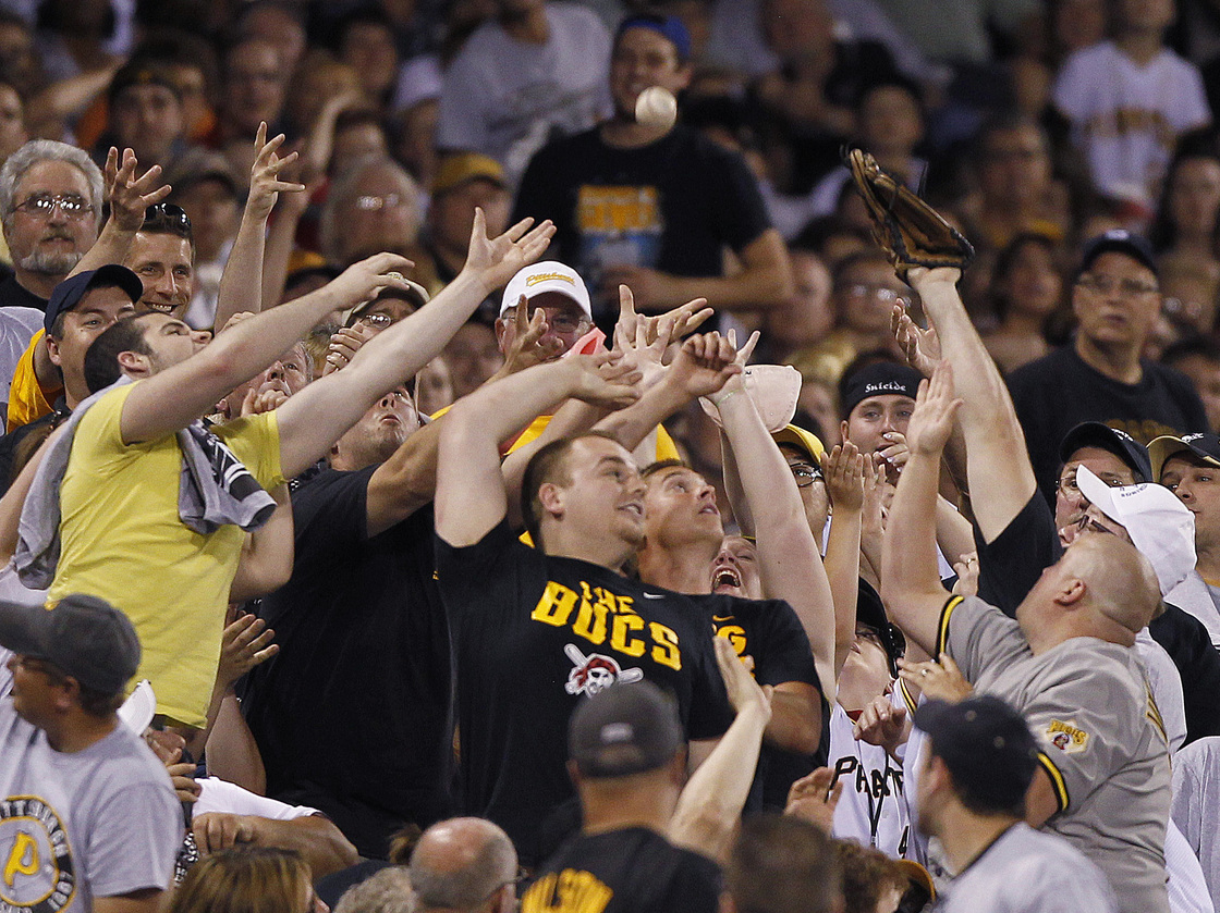 Pittsburgh Pirates fans reach for a foul ball hit into the stands by Mike Moustakas of the Kansas City Royals in the seventh inning of a game in Pittsburgh.