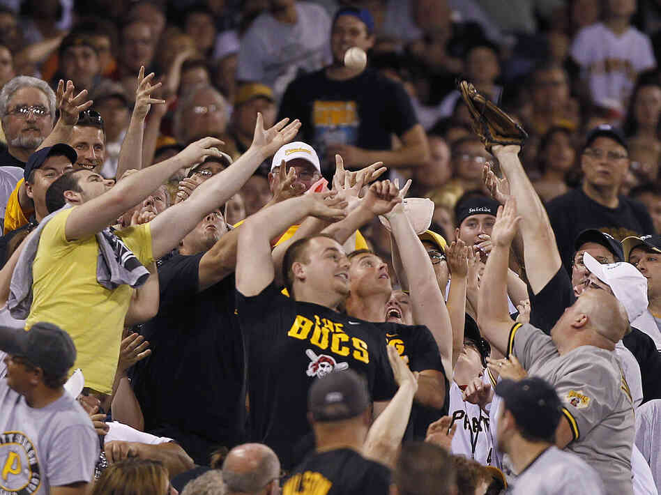 Pittsburgh Pirates fans reach for a foul ball hit into the stands by Mike Moustakas of the Kansas City Royals in the seventh inning of a game in Pittsburgh.